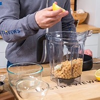 Person making hummus in blender