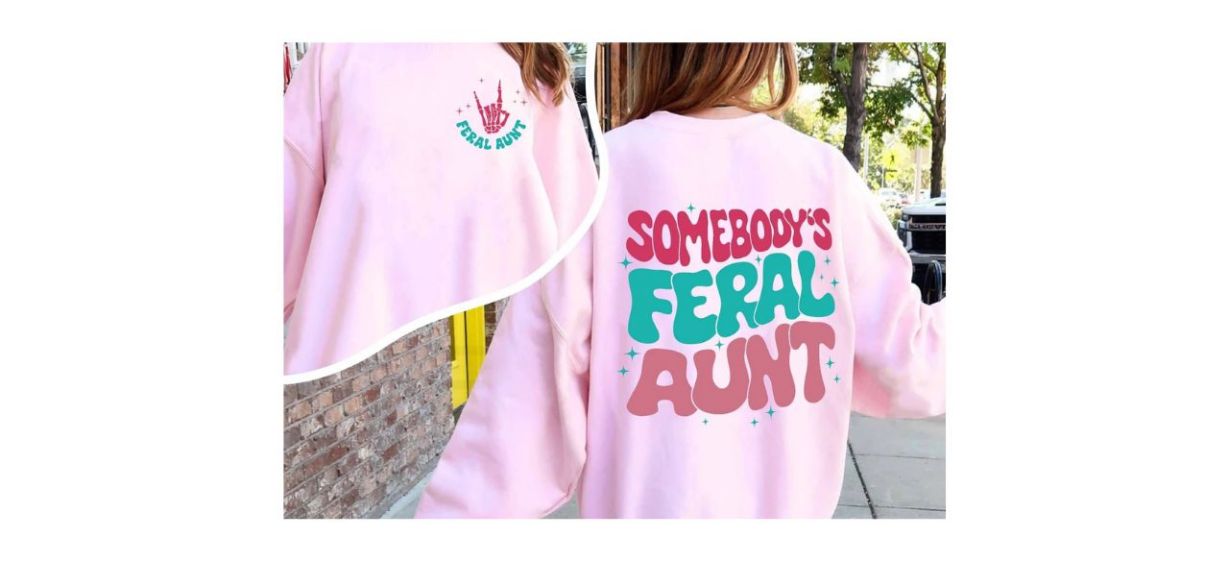 pink sweatshirt that says &quot;Somebody's feral aunt&quot; on it