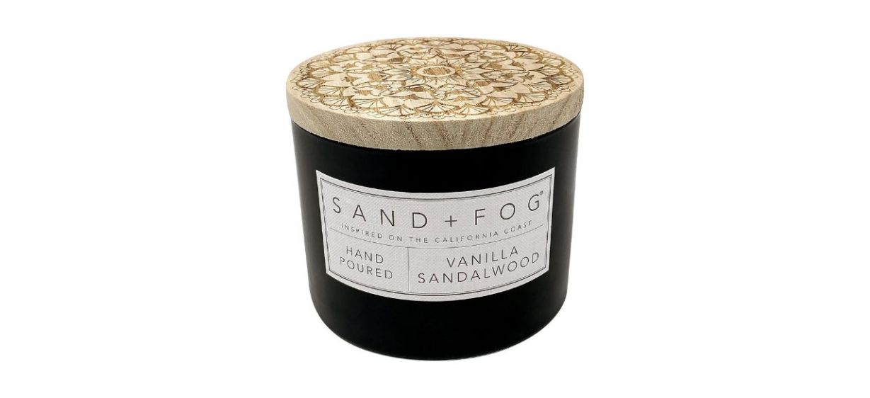 black jar with Sand + Fog Scented Candle inside; text says it's hand-poured and inspired on the California coast.